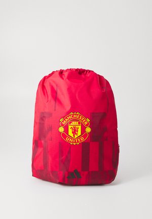 Sac de sport rouge à cordon avec des motifs géométriques rouge foncé, logo de Manchester United en jaune et rouge, et logo Adidas noir en bas.