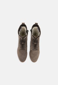 Braune Wildleder-Stiefeletten mit Schnürdesign und Reißverschlüssen an den Seiten. Weiches Innenfutter, flache Gummisohlen und abgestepptes Detail entlang der Kanten.