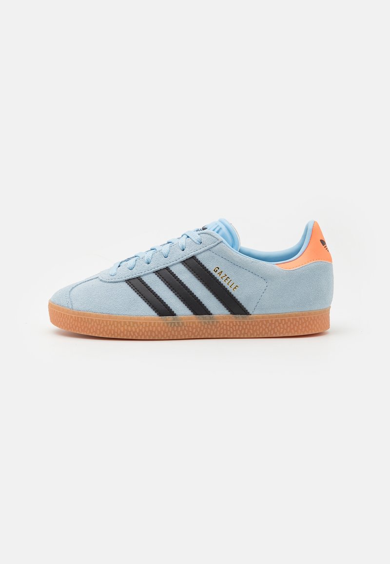 Light blue suede sneaker with black stripes and gold "Gazelle" branding. Features a gum rubber sole and an orange accent on the heel.