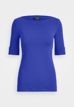 T-shirt ajusté bleu avec un col arrondi et des manches trois-quarts. Le tissu est doux avec un léger effet stretch ; les manches sont retroussées.