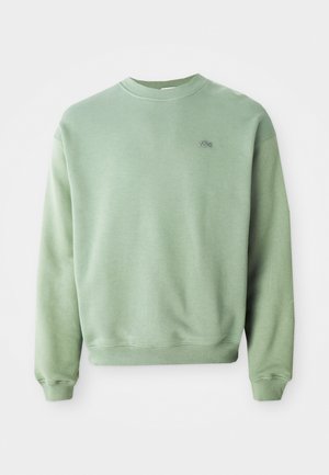 Light green crewneck sweatshirt with long sleeves and a small embroidered crocodile logo on the left chest.