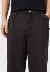 Μαύρο βαμβακερό παντελόνι με άνετη εφαρμογή, διαθέτοντας μπροστινές τσέπες, κούμπωμα με κουμπί και διακριτικές ραφές.