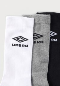 Három pár bordázott zokni: fehér, szürke és fekete. Mindegyiken fekete "Umbro" logó található az oldalon. Pamut keverék anyagból.