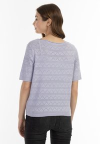 Fialový pletený top s krátkými rukávy, kulatým výstřihem a geometrickým vzorem malých otvorů a cikcakového designu. Texturovaný povrch.