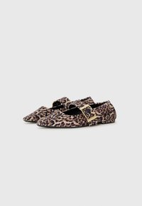Sapatos planos com padrão de leopardo, bicos apontados, detalhes em fivela dourada, tecido suave e uma ribana elástica preta na abertura.