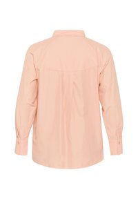 Blusa de color rosa claro, de manga larga, hecha de algodón, con cuello, pliegue en la parte posterior y puños abotonados. Textura suave y corte holgado.