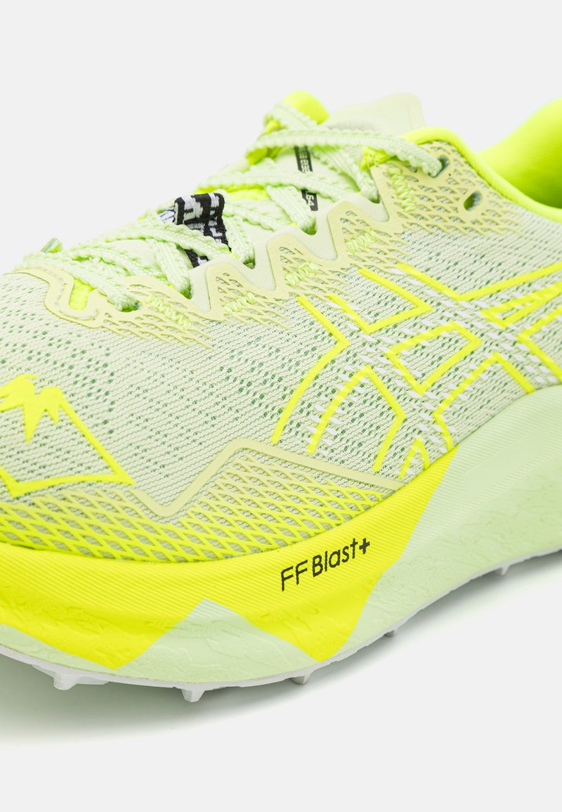 Zapatilla de running amarilla neón con parte superior de malla texturizada, sistema de lazado reforzado y tecnología de amortiguación FF Blast+ en la suela.