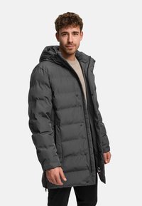 Donkergrijze gewatteerde jas met capuchon, voorzien van een doorgestikt ontwerp, drukknoopsluiting aan de voorkant en ritszakken aan de zijkanten voor extra functionaliteit.