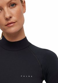 Czarny sportowy top z wysokim dekoltem, z prążkowanymi ramionami i logo na klatce piersiowej. Gładka tekstura, dopasowany krój, smukła sylwetka.