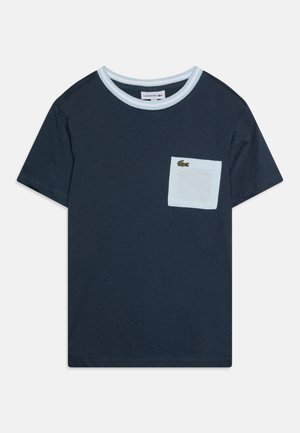 Σκούρο μπλε βαμβακερό μπλουζάκι με ανοιχτό μπλε ριγωτό γιακά και ανοιχτό μπλε τσέπη στο στήθος, διακοσμημένη με λογότυπο πράσινου κροκόδειλου. Κοντά μανίκια.