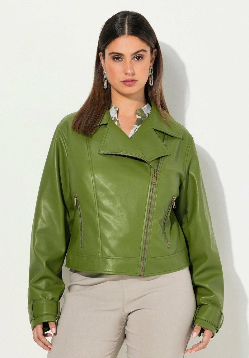 Veste cropped en simili cuir vert avec un col en V, des poches zippées et des manches longues. Texture lisse et silhouette moderne.