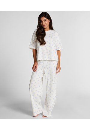 Ensemble de pyjama blanc avec des motifs bleu clair sur un haut à coupe décontractée et un pantalon à jambe large. Tissu doux avec des manches courtes et un design surdimensionné.
