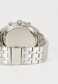 Ατσάλινο ρολόι χρονογράφου από ανοιχτόχρυσο ατσάλι με αρθρωτό μπρασελέ. Λείο πίσω μέρος και γυαλιστερός μηχανισμός με χαρακτική του λογότυπου στο κούμπωμα.