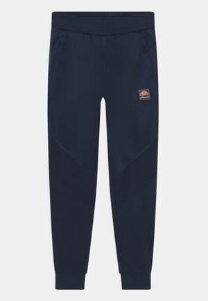 Marineblauwe taps toelopende joggers met geribbelde kniekappen, zijzakken, elastische tailleband en Ellesse-logo patch op de bovenste linker dij.