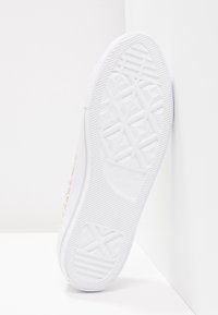 Suela de zapatilla blanca con un diseño de goma texturizada y un patrón geométrico, marcada "Converse All Star", y un borde suave.