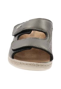 Sandalo in pelle nera con due cinghie regolabili in Velcro, design con punta aperta, soletta in sughero e suola bianca texturizzata. Accenti in metallo argentato.