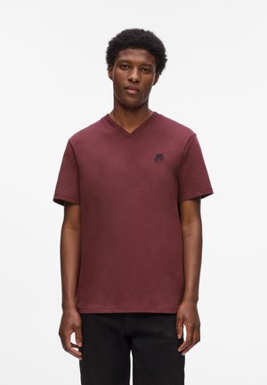Bordeaux korte mouwen V-hals T-shirt van katoen, met een klein zwart logo op de borst en een gladde textuur.
