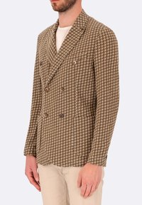 Giacca doppiopetto in tessuto marrone a motivo houndstooth, con texture, dotata di quattro bottoni frontali e una vestibilità sartoriale.