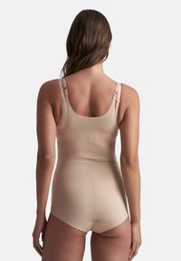 Body shaper nude con spalline larghe, texture liscia e design aderente. Include spalline regolabili e lunghezza a metà coscia.