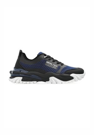 Baskets de sport en mesh noir et bleu marine avec une tige texturée, une semelle blanche et un détail de rembourrage prononcé au niveau du talon.