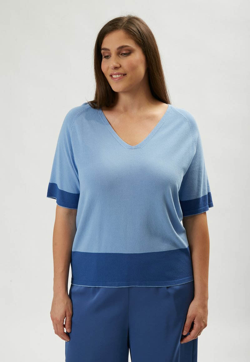 Hellblaues V-Ausschnitt-Pullover mit kurzen Ärmeln, der einen dunkleren blauen Streifen am Saum und an den Ärmeln aufweist, mit weicher Textur und lässiger Passform.