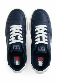 Granatowe syntetyczne sneakersy z białymi sznurowadłami, okrągłym noskiem i teksturowaną skórzaną cholewką. Zawierają czerwono-biało-niebieskie logo po boku.