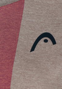 Camiseta de manga corta que presenta una mezcla de tela texturada en tonos rosa y beige, con un destacado diseño de logo negro en la parte frontal.