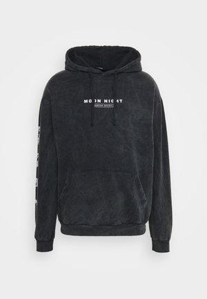 Sudadera negra con capucha, bolsillo frontal, cordón en la capucha, texto "MOON NIGHT" en el pecho y rayas gráficas a lo largo de las mangas.