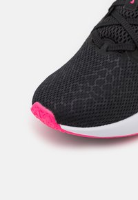 Musta urheilukenkä, jossa on teksturoitu verkkopäällinen, vaaleanpunainen kumipohja ja valkoinen välipohja. Perinteinen nauhoitusjärjestelmä.