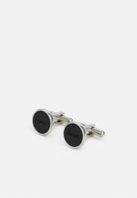 Boutons de manchette ronds avec un cadre en métal de coloris argenté. Centre circulaire noir avec le texte gravé "HUGO". Fini poli, design classique.