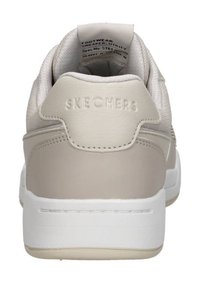 Sneaker Skechers in pelle beige e rete, con colletto imbottito, suola bianca e logo in rilievo sul tallone. Texture liscia e design pulito.