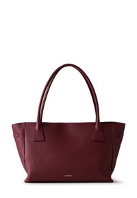 Burgundy leather tote bag with a textured finish, two sturdy handles, and a minimalist design. Features gold logo at the bottom.