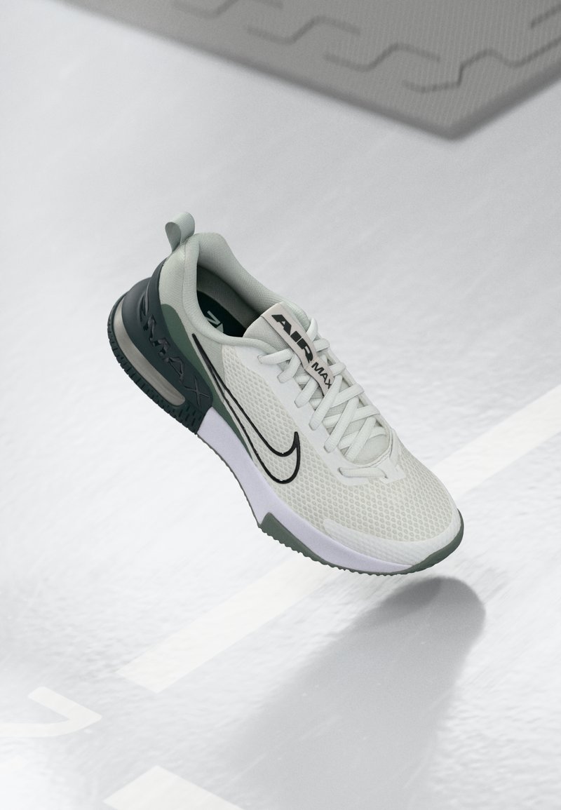White and light green athletic shoe with a mesh upper, black accents, and a padded tongue. Features cushioned sole with "AIR MAX" branding.