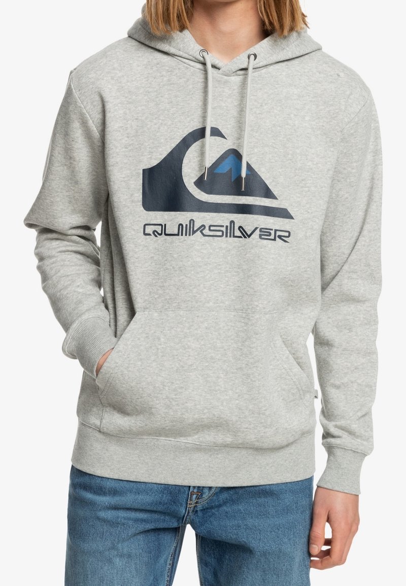 Sudadera con capucha gris hecha de tela suave, con un gran logo de Quiksilver en azul marino y azul que presenta un diseño de montaña y ola. Bolsillo tipo canguro en la parte delantera.