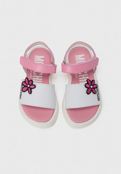 Ροζ και λευκά σανδάλια με λουράκι μπροστά διακοσμημένο με άνθος, ρυθμιζόμενο λουράκι αστραγάλου και λογότυπο στη σόλα. Υφή στην επιφάνεια.