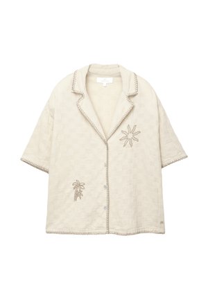 Light beige short-sleeve shirt with a woven texture, decorative palm tree and sun embroidery, and contrasting stitching along the edges.