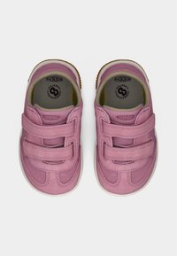 Chaussures pour enfants roses en matériau synthétique, dotées de deux brides Velcro ajustables, de semelles texturées et de semelles intérieures rembourrées.