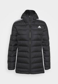 Veste matelassée noire à fermeture éclair sur le devant, col montant et logo Adidas. Présente un motif matelassé horizontal et des bandes blanches sur les côtés.