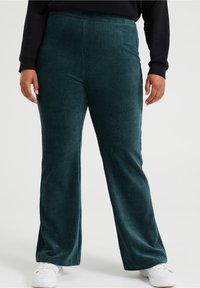 Mi bluzy korduroy w kolorze teal z prostymi prążkami, z wysokim stanem, w połączeniu z białymi trampkami.