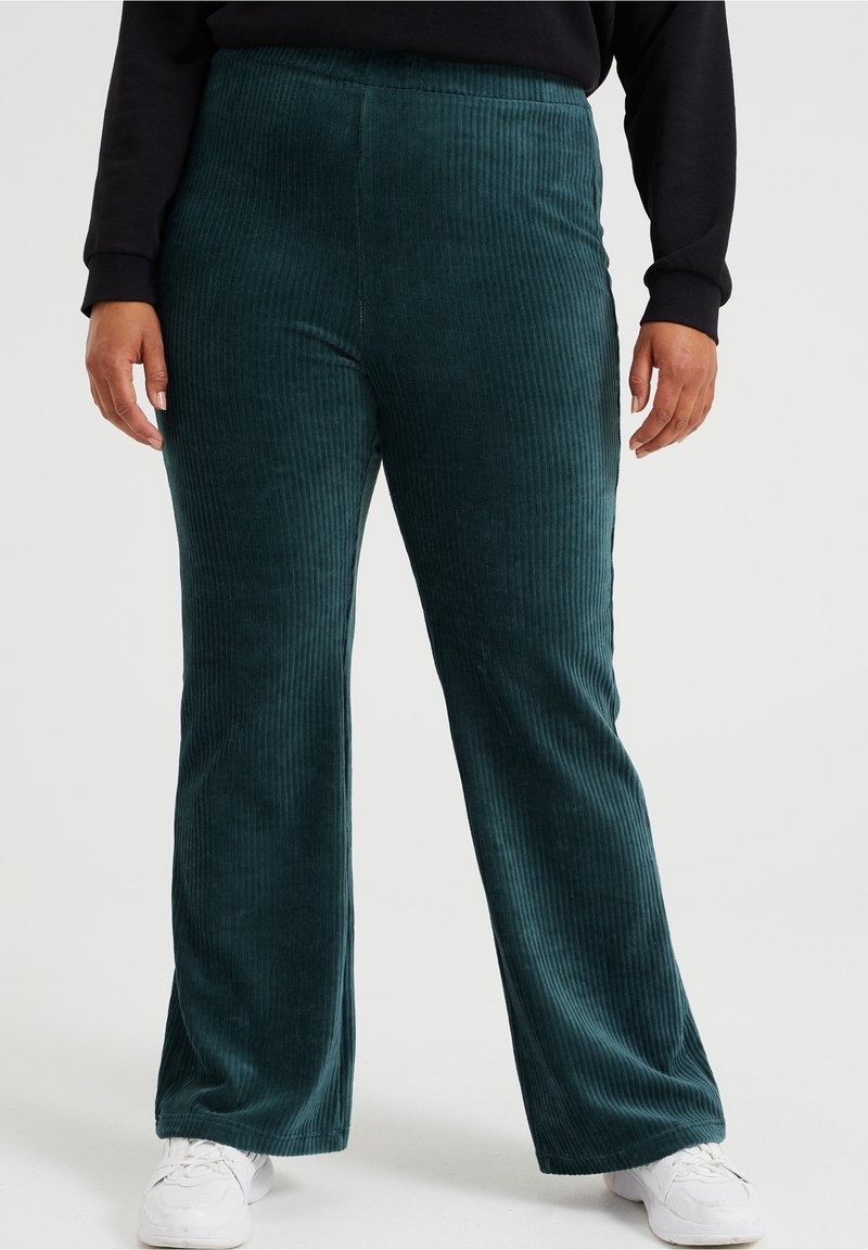 Mi bluzy korduroy w kolorze teal z prostymi prążkami, z wysokim stanem, w połączeniu z białymi trampkami.