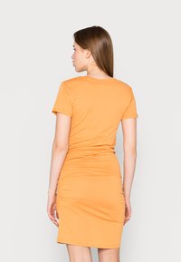 Vestido laranja de manga curta com silhueta ajustada, apresentando pregas laterais para textura e um design de gola redonda.