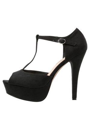 Chaussure à talon haut en daim noir avec une plateforme, un design à bride en T, un bout ouvert et une boucle à la cheville. Présente une silhouette incurvée et une surface texturée.