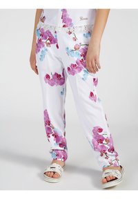 Białe spodnie w kwiatowy wzór z różowymi i niebieskimi orchideami, z koronkowym wykończeniem w pasie i luźnym krojem.