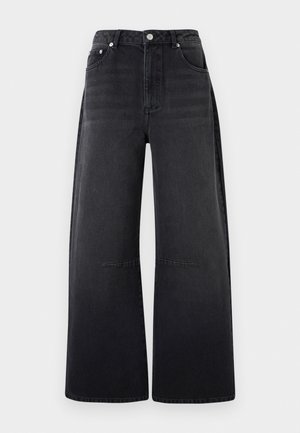 Svarte denimjeans med vide bein, høyt liv, frontknapper og glidelås, samt fem lommer, på hvit bakgrunn.