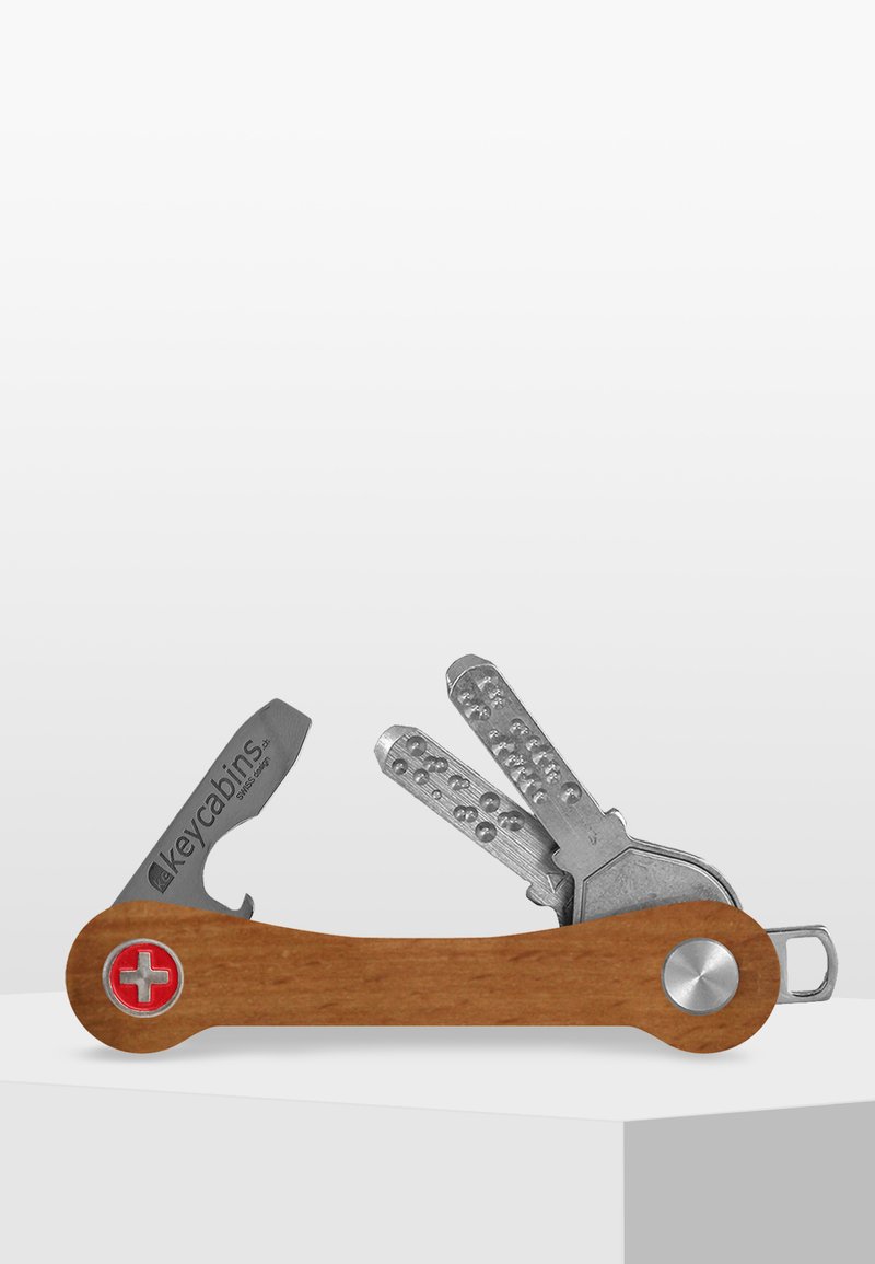 Trä-multiverktyg med silvermetalldetaljer, som har nyckelhållare och flera verktyg, inklusive en skruvmejsel och en flasköppnare.