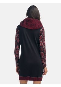 Robe noire avec des manches à motif floral et un col châle côtelé bordeaux. Présente une coupe ajustée et un ourlet festonné en bas.