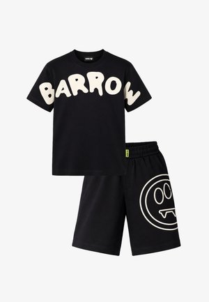 T-shirt nera a maniche corte con grande scritta bianca "BARROW" e pantaloncini neri abbinati con una faccina sorridente contornata di bianco e con zanne.