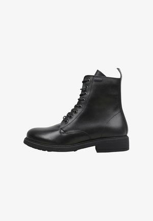 Bottines en cuir noir avec fermeture à lacets, bout arrondi et semelle texturée. Présente un détail d'étiquette sur le côté et un talon bloc plat.