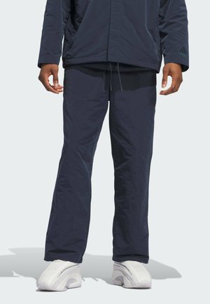 Pantaloni da jogging navy realizzati in tessuto leggero, con un design a gamba dritta e un cordino in vita regolabile, abbinati a sneakers bianche.