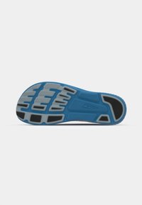 Semelle de chaussure conçue pour l'adhérence avec une base bleue, des accents en caoutchouc noir et des motifs texturés gris, y compris des rainures pour la prise et la flexibilité.